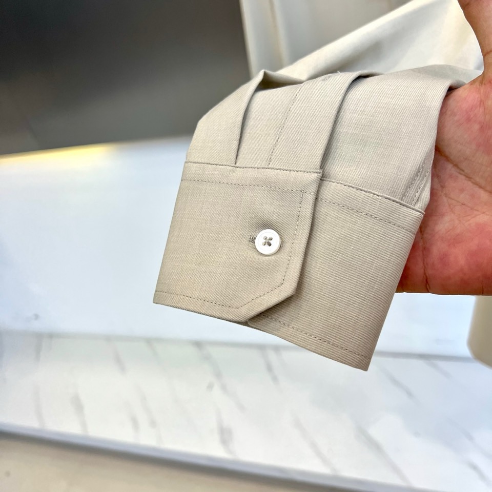 Kiton-2025秋冬新品匠心工艺衬衫。这款卡其色衬衫采用经典翻领设计，前襟搭配五颗天然母贝纽扣，左胸