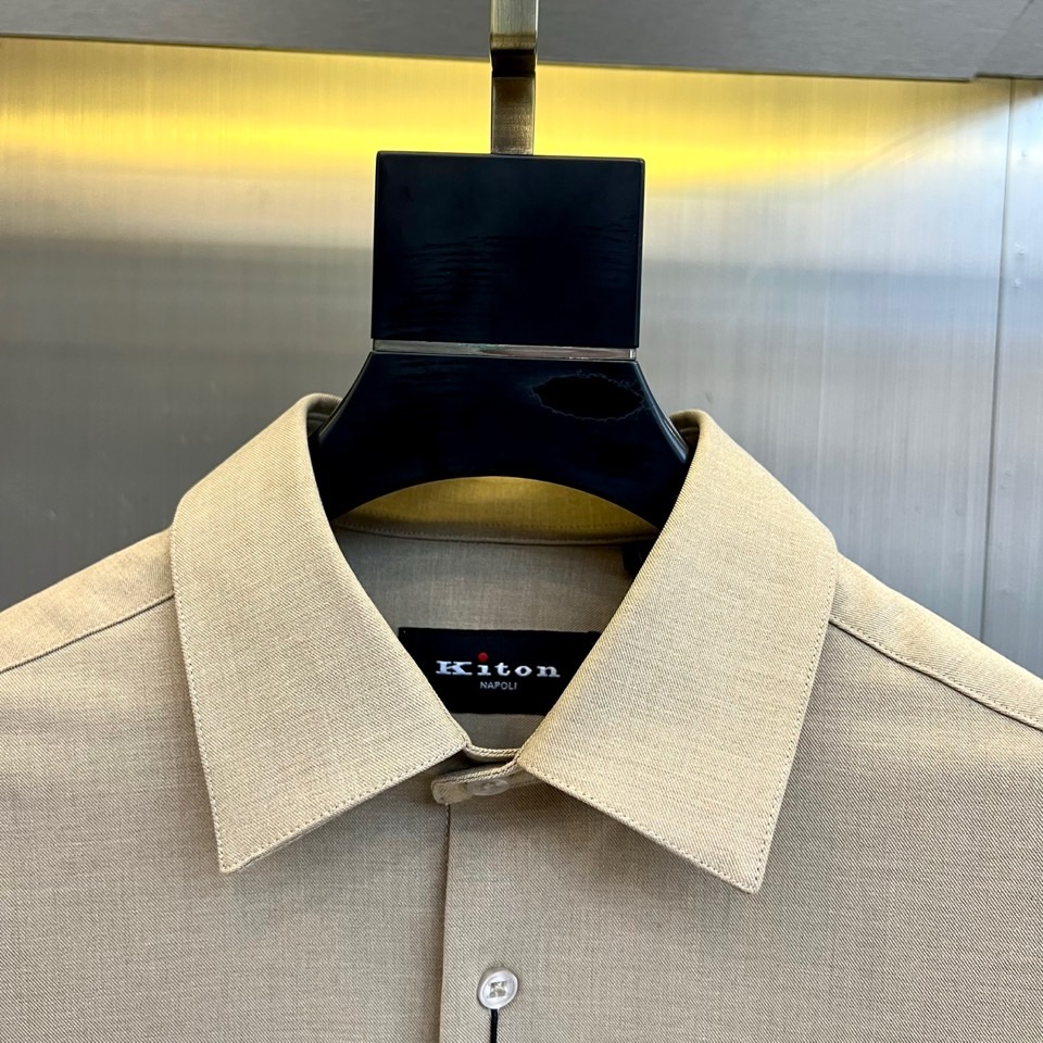 Kiton-2025秋冬新品匠心工艺衬衫。这款卡其色衬衫采用经典翻领设计，前襟搭配五颗天然母贝纽扣，左胸