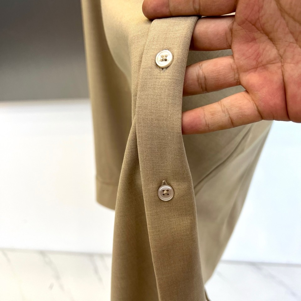 Kiton-2025秋冬新品匠心工艺衬衫。这款卡其色衬衫采用经典翻领设计，前襟搭配五颗天然母贝纽扣，左胸