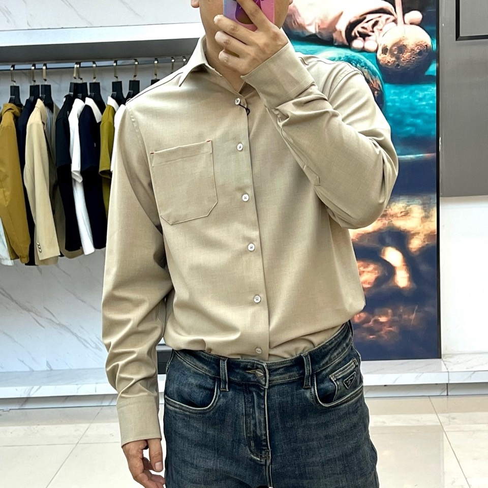 Kiton-2025秋冬新品匠心工艺衬衫。这款卡其色衬衫采用经典翻领设计，前襟搭配五颗天然母贝纽扣，左胸