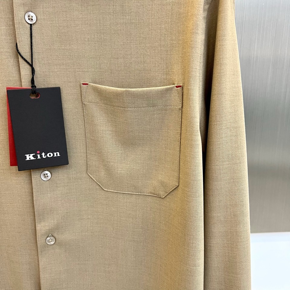 Kiton-2025秋冬新品匠心工艺衬衫。这款卡其色衬衫采用经典翻领设计，前襟搭配五颗天然母贝纽扣，左胸