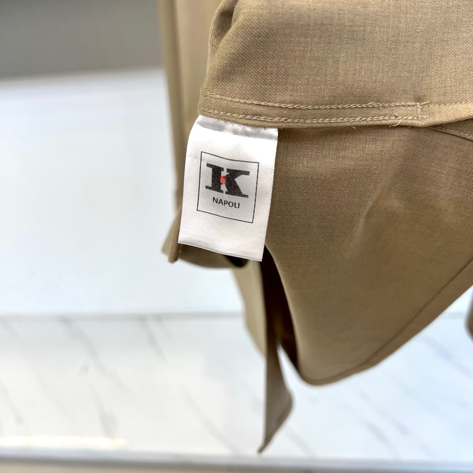 Kiton-2025秋冬新品匠心工艺衬衫。这款卡其色衬衫采用经典翻领设计，前襟搭配五颗天然母贝纽扣，左胸