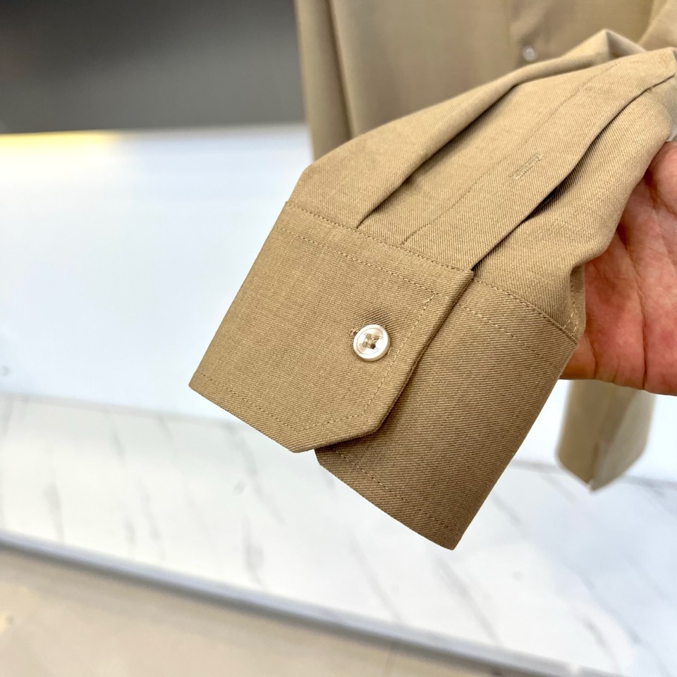 Kiton-2025秋冬新品匠心工艺衬衫。这款卡其色衬衫采用经典翻领设计，前襟搭配五颗天然母贝纽扣，左胸