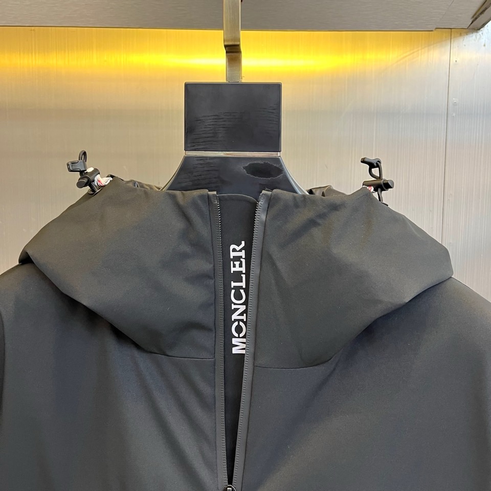MON蒙口（高端鹅绒）、2025秋冬新品男士连帽羽绒外套，色调演绎现代户外机能风格。连帽设计搭配红白蓝三