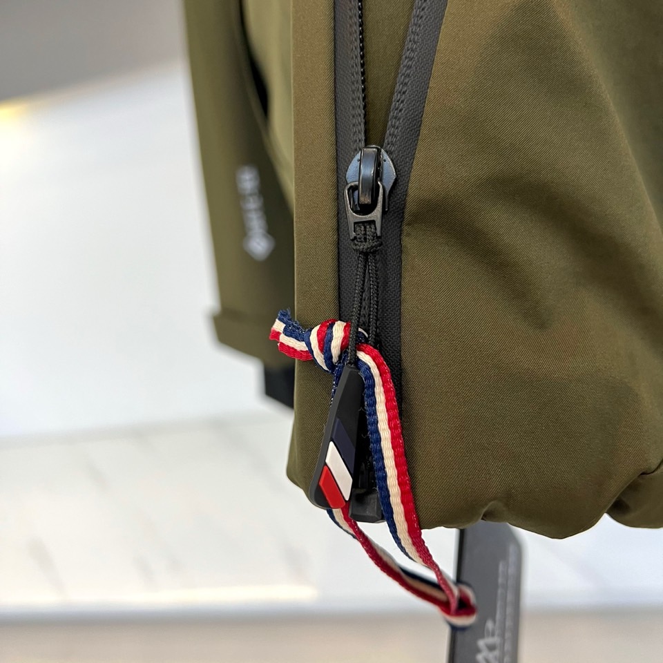 MON蒙口（高端鹅绒）、2025秋冬新品男士连帽羽绒外套，色调演绎现代户外机能风格。连帽设计搭配红白蓝三