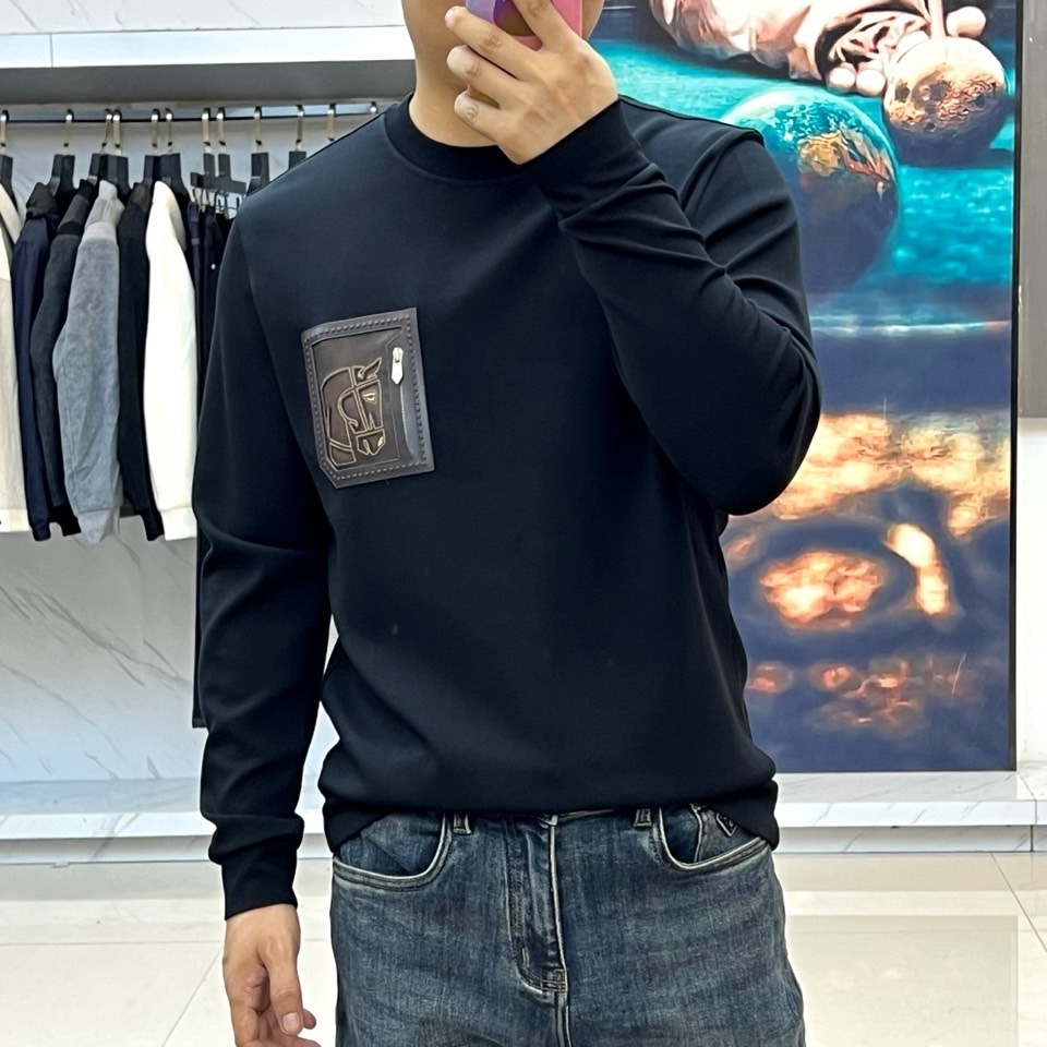 H爱马仕、2025秋冬新品 HERMÈS经典徽章长袖卫衣。这款深紫红色长袖T恤采用品牌标志性圆领设计，左