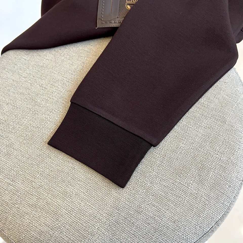 H爱马仕、2025秋冬新品 HERMÈS经典徽章长袖卫衣。这款深紫红色长袖T恤采用品牌标志性圆领设计，左