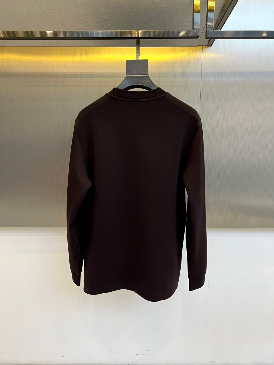 H爱马仕、2025秋冬新品 HERMÈS经典徽章长袖卫衣。这款深紫红色长袖T恤采用品牌标志性圆领设计，左
