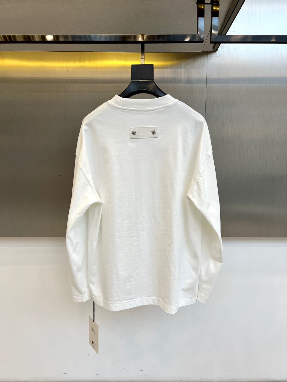 Ch克罗心、2025秋冬新品男士长袖T恤，以纯净白色基底诠释现代街头美学。采用经典圆领设计与宽松剪裁，两