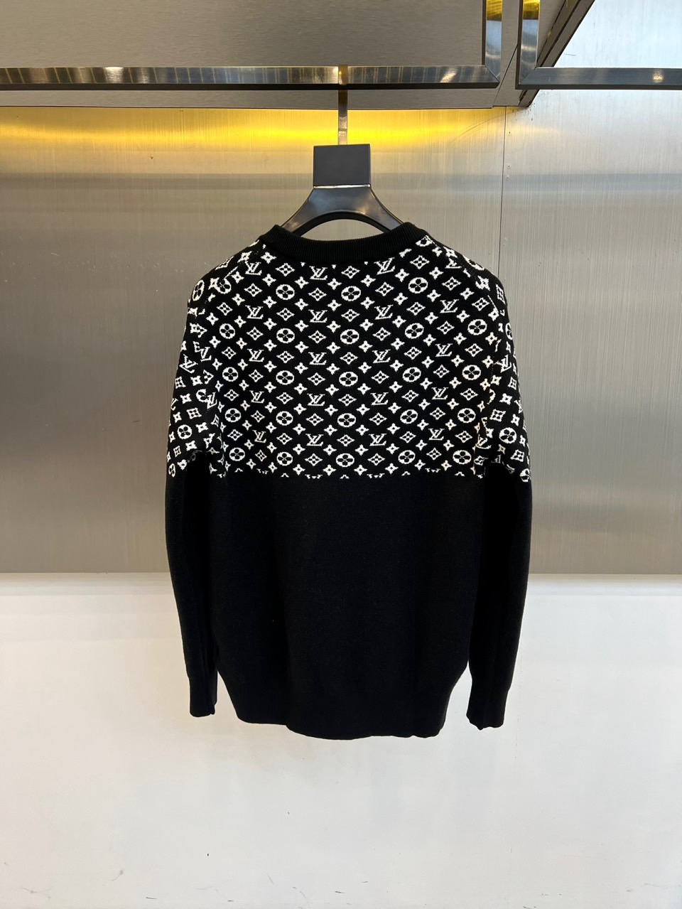 1v威登、2025秋冬新品毛衣以颠覆性设计诠释品牌经典基因。这款黑色圆领毛衣采用创新的双层结构设计，上半