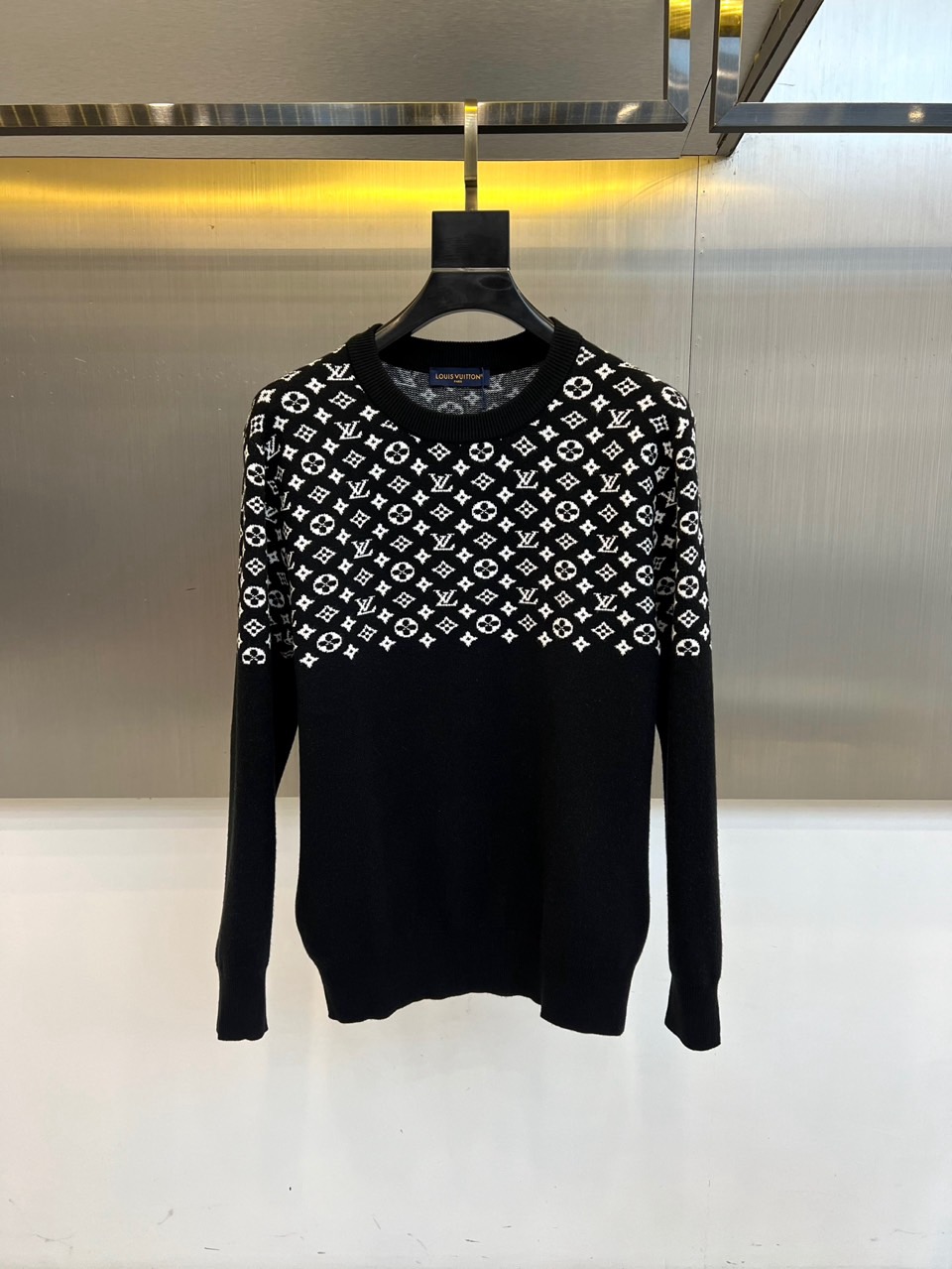 1v威登、2025秋冬新品毛衣以颠覆性设计诠释品牌经典基因。这款黑色圆领毛衣采用创新的双层结构设计，上半