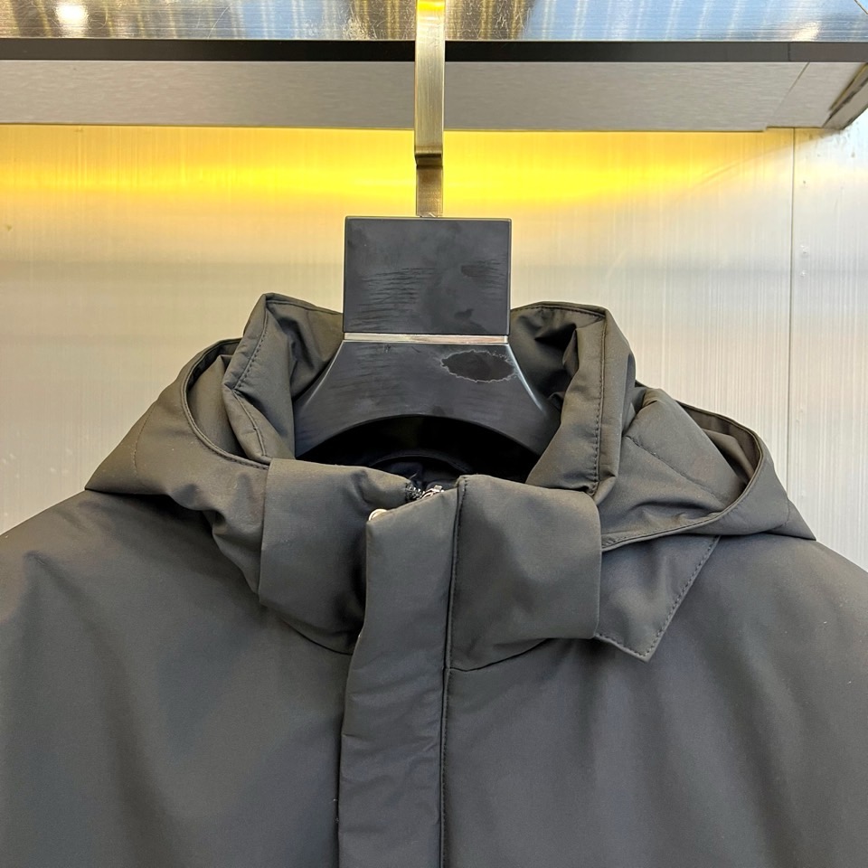 Prad普拉达、2025秋冬新款棉服以深邃藏蓝色演绎都市实用美学。这款连帽棉服采用立体绗缝工艺形成规整的