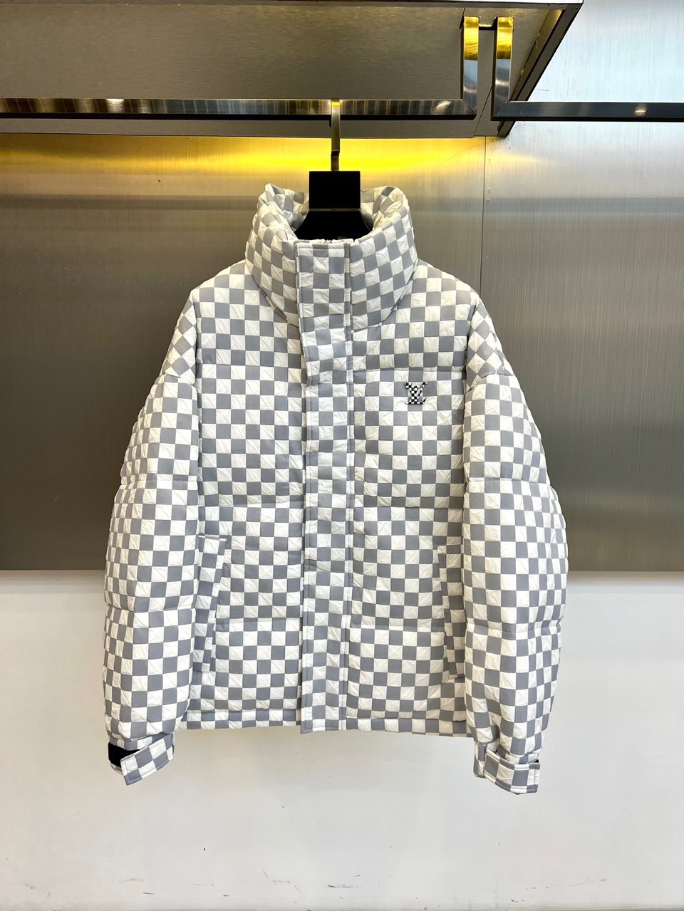 1v威登、2025秋冬新品羽绒服，以品牌标志性棋盘格纹绗缝演绎现代冬日奢华。高领设计搭配精准的菱形绗缝走