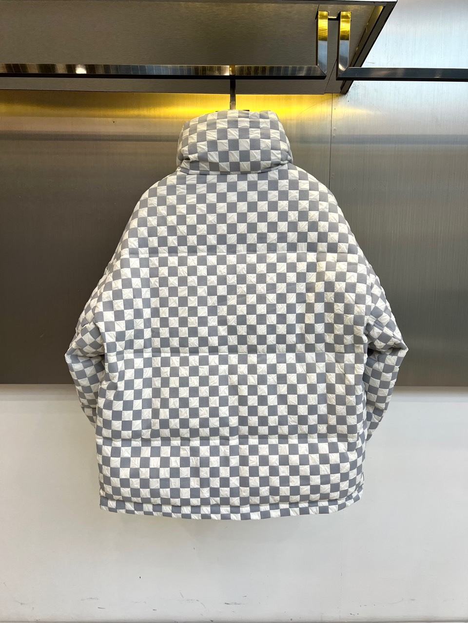 1v威登、2025秋冬新品羽绒服，以品牌标志性棋盘格纹绗缝演绎现代冬日奢华。高领设计搭配精准的菱形绗缝走