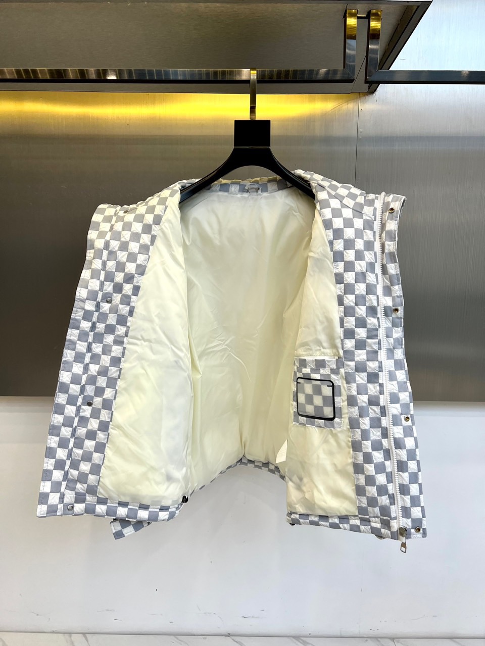 1v威登、2025秋冬新品羽绒服，以品牌标志性棋盘格纹绗缝演绎现代冬日奢华。高领设计搭配精准的菱形绗缝走