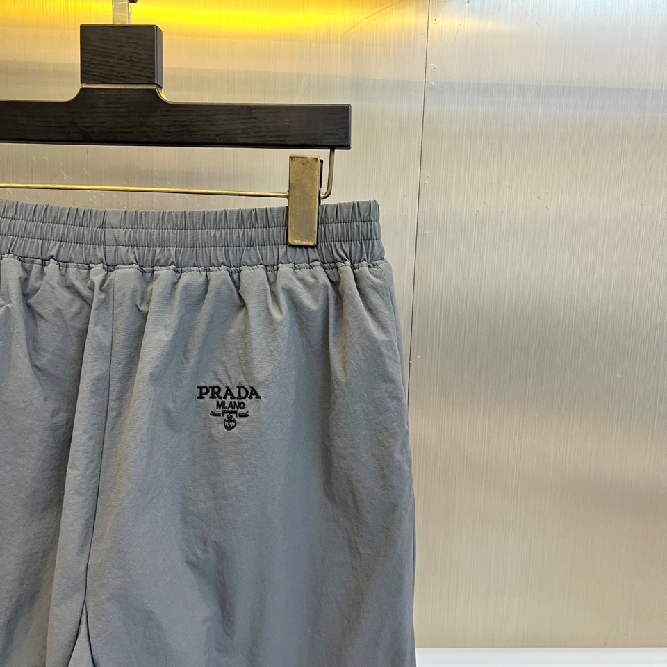 Prad普拉达、2025秋冬新品户外羽绒裤，以浅卡其色演绎山野与都市的跨界美学。这款羽绒裤采用立体剪裁工