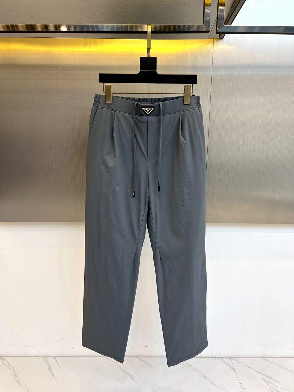 Prad普拉达、2025秋冬新品户外羽绒裤，以浅卡其色演绎山野与都市的跨界美学。这款羽绒裤采用立体剪裁工