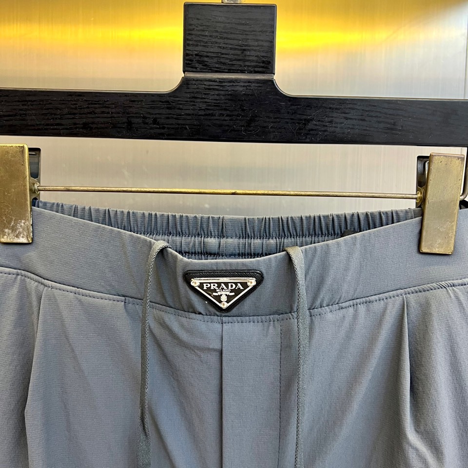 Prad普拉达、2025秋冬新品户外羽绒裤，以浅卡其色演绎山野与都市的跨界美学。这款羽绒裤采用立体剪裁工