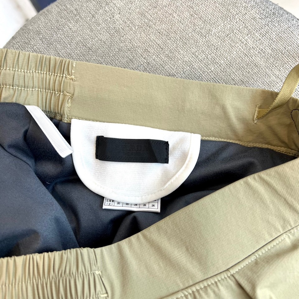 Prad普拉达、2025秋冬新品户外羽绒裤，以浅卡其色演绎山野与都市的跨界美学。这款羽绒裤采用立体剪裁工