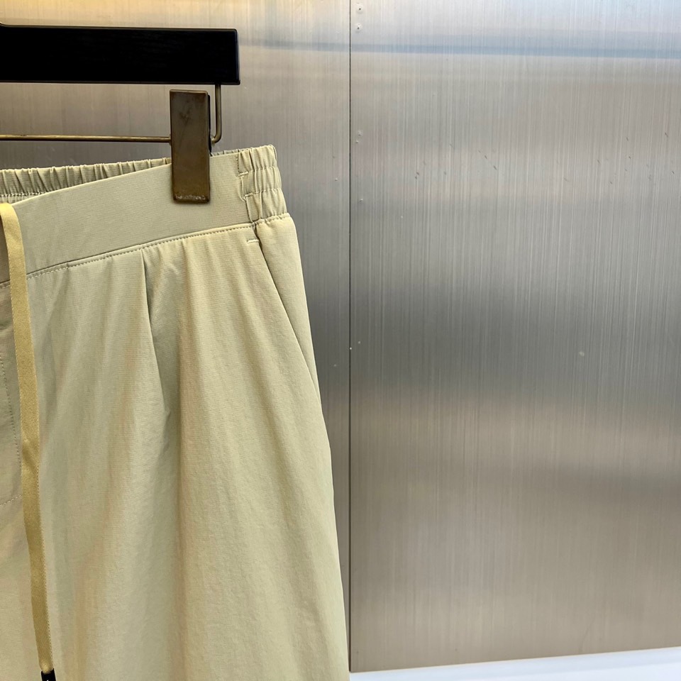 Prad普拉达、2025秋冬新品户外羽绒裤，以浅卡其色演绎山野与都市的跨界美学。这款羽绒裤采用立体剪裁工