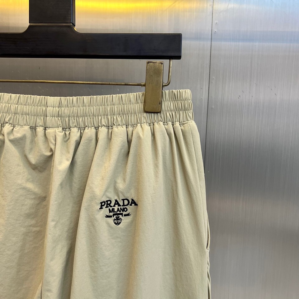 Prad普拉达、2025秋冬新品户外羽绒裤，以浅卡其色演绎山野与都市的跨界美学。这款羽绒裤采用立体剪裁工
