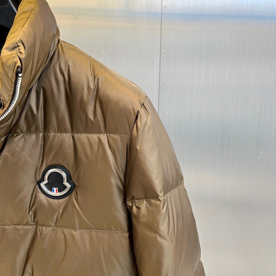 Mon蒙口、2025秋冬新品羽绒服，这款羽绒服采用立领设计与防风拉链开合系统，两侧斜插口袋装饰金属按扣，