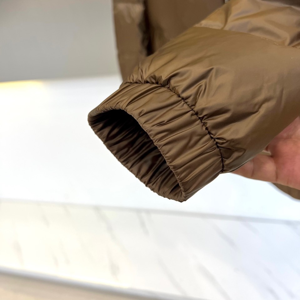 Mon蒙口、2025秋冬新品羽绒服，这款羽绒服采用立领设计与防风拉链开合系统，两侧斜插口袋装饰金属按扣，