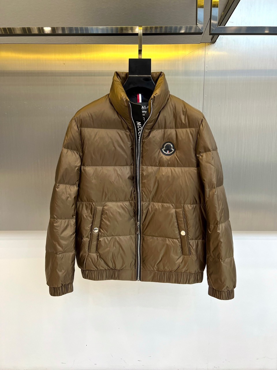 Mon蒙口、2025秋冬新品羽绒服，这款羽绒服采用立领设计与防风拉链开合系统，两侧斜插口袋装饰金属按扣，