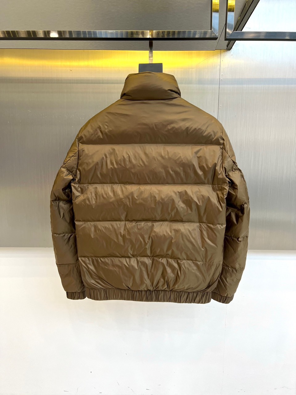 Mon蒙口、2025秋冬新品羽绒服，这款羽绒服采用立领设计与防风拉链开合系统，两侧斜插口袋装饰金属按扣，