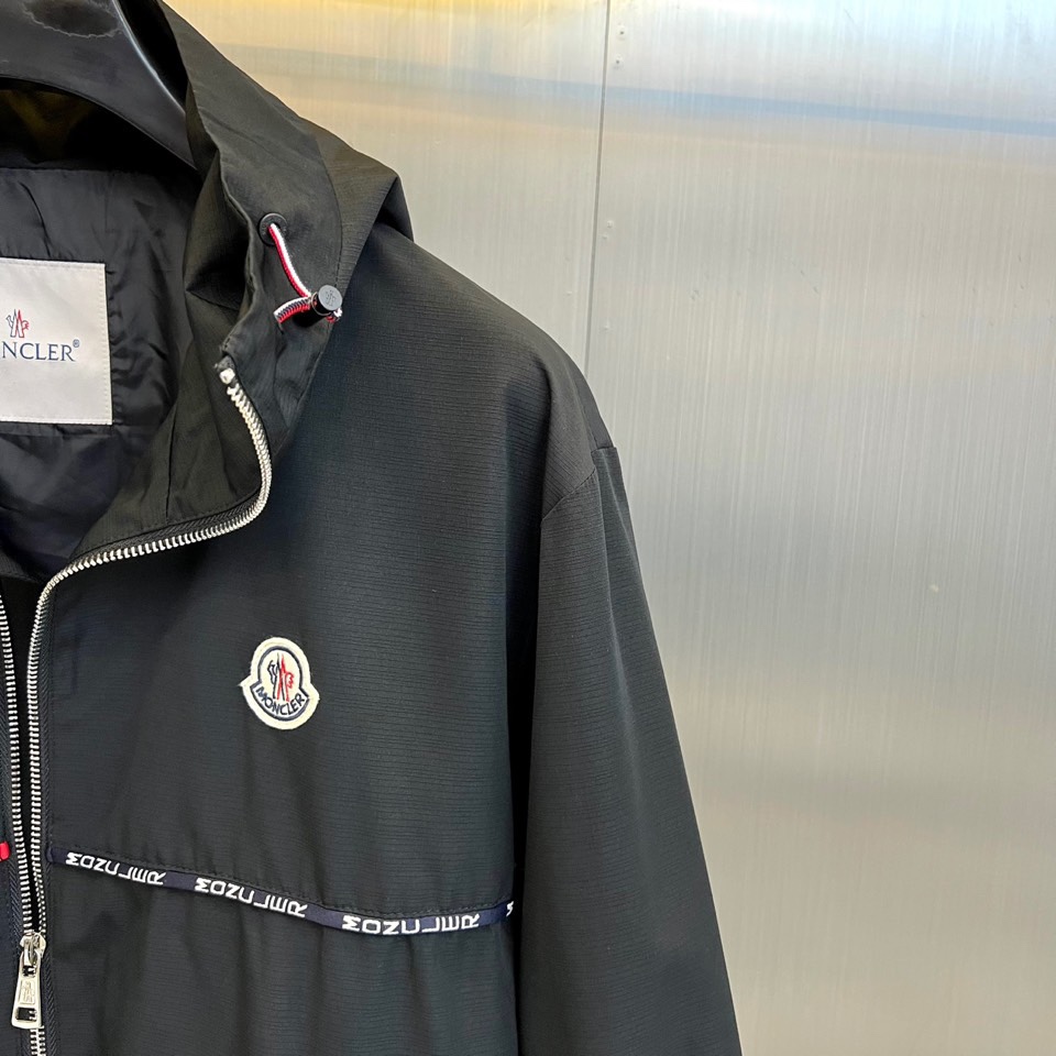 Mon蒙口、2025秋冬新品夹克，这款连帽夹克采用防风面料制作，顺滑的黑色拉链自下摆延伸至立领，左侧帽绳