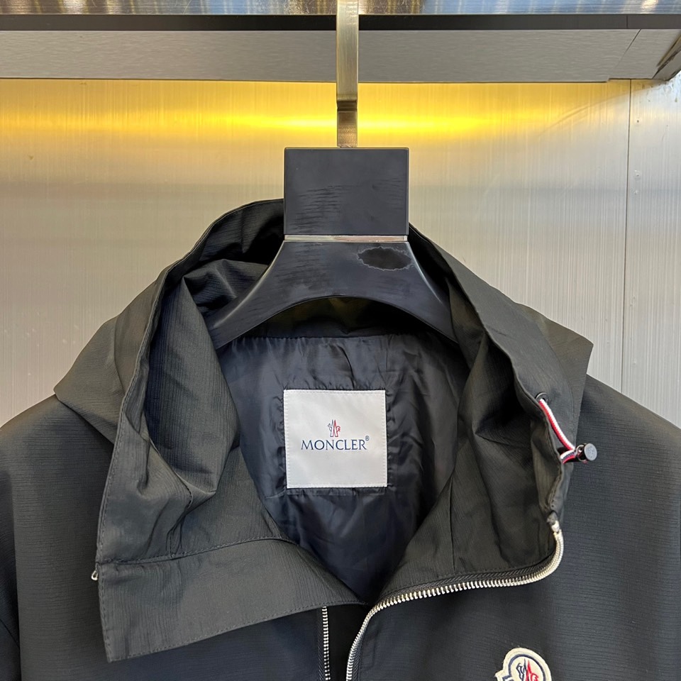 Mon蒙口、2025秋冬新品夹克，这款连帽夹克采用防风面料制作，顺滑的黑色拉链自下摆延伸至立领，左侧帽绳