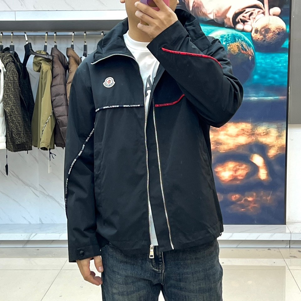 Mon蒙口、2025秋冬新品夹克，这款连帽夹克采用防风面料制作，顺滑的黑色拉链自下摆延伸至立领，左侧帽绳