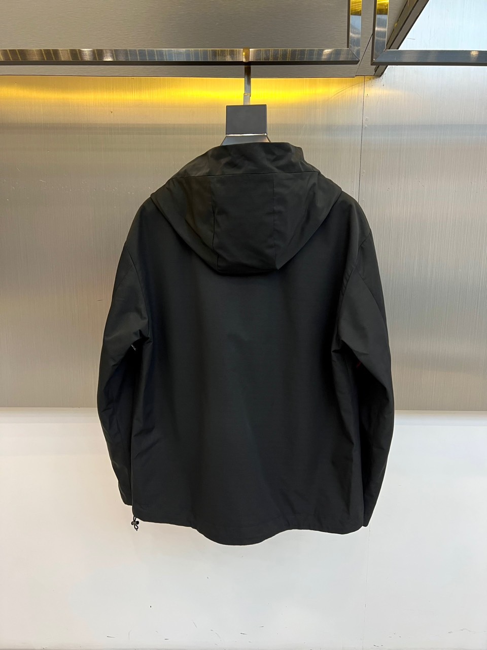 Mon蒙口、2025秋冬新品夹克，这款连帽夹克采用防风面料制作，顺滑的黑色拉链自下摆延伸至立领，左侧帽绳
