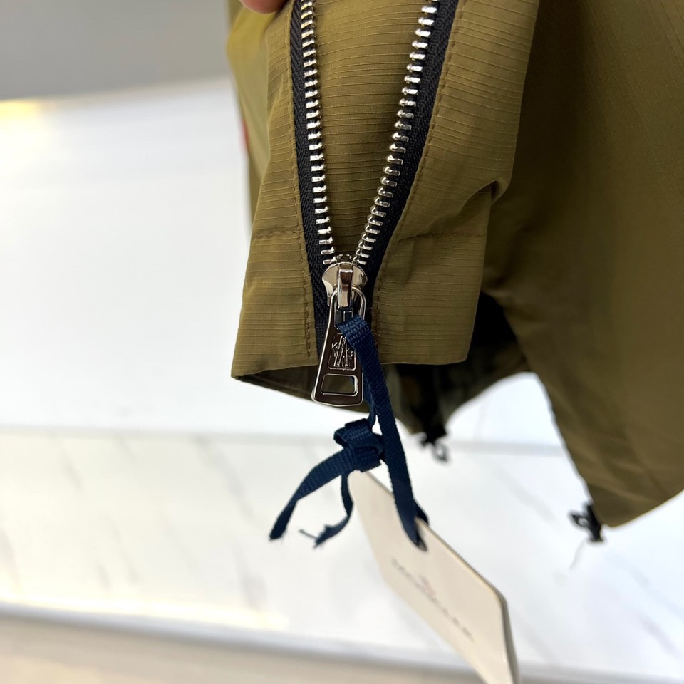 Mon蒙口、2025秋冬新品夹克，这款连帽夹克采用防风面料制作，顺滑的黑色拉链自下摆延伸至立领，左侧帽绳