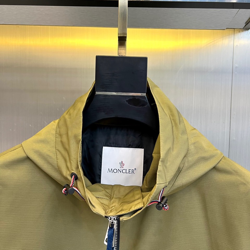 Mon蒙口、2025秋冬新品夹克，这款连帽夹克采用防风面料制作，顺滑的黑色拉链自下摆延伸至立领，左侧帽绳