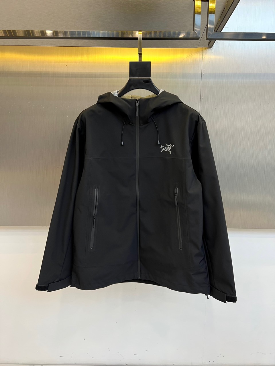 Arcteryx 始祖鸟、2025秋冬新款冲锋衣以经典黑色演绎专业户外美学。这款连帽冲锋衣采用品牌独家G