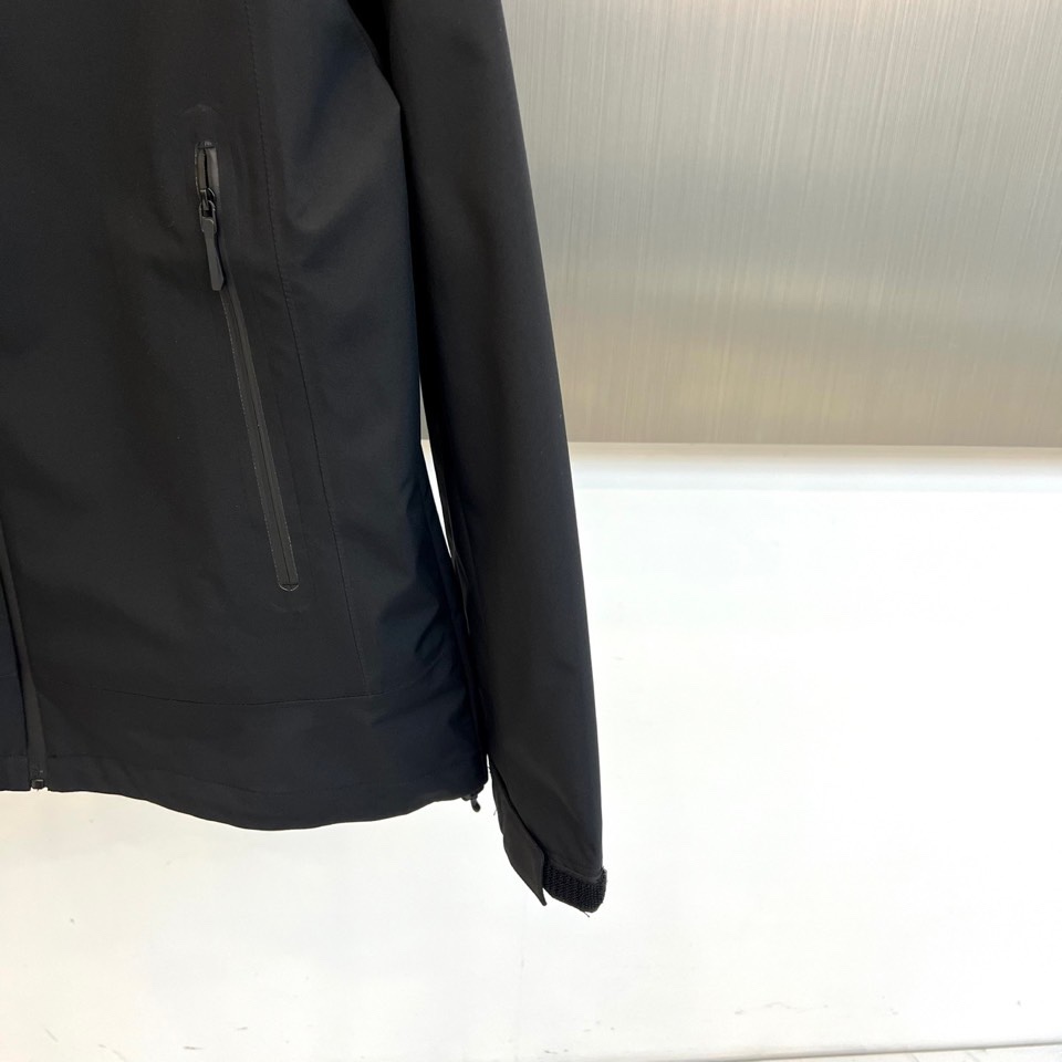 Arcteryx 始祖鸟、2025秋冬新款冲锋衣以经典黑色演绎专业户外美学。这款连帽冲锋衣采用品牌独家G
