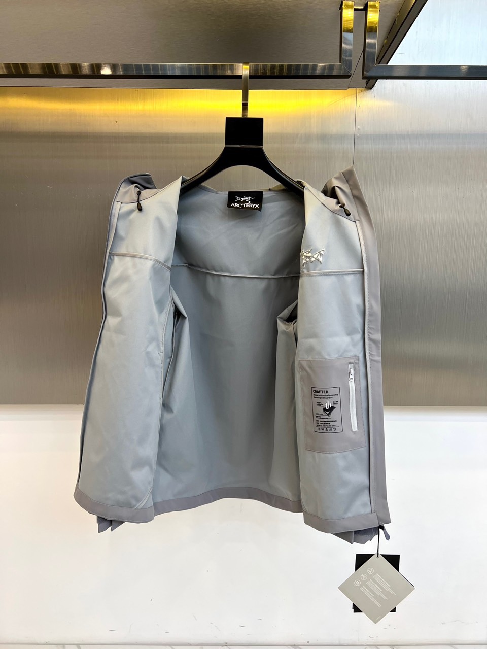 Arcteryx 始祖鸟、2025秋冬新款冲锋衣以浅灰色调诠释专业户外美学。这款连帽冲锋衣采用品牌独家G