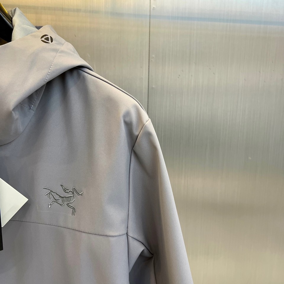 Arcteryx 始祖鸟、2025秋冬新款冲锋衣以浅灰色调诠释专业户外美学。这款连帽冲锋衣采用品牌独家G