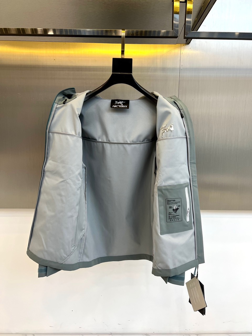Arcteryx 始祖鸟、2025秋冬新款冲锋衣以浅灰色调诠释专业户外美学。这款连帽冲锋衣采用品牌独家G