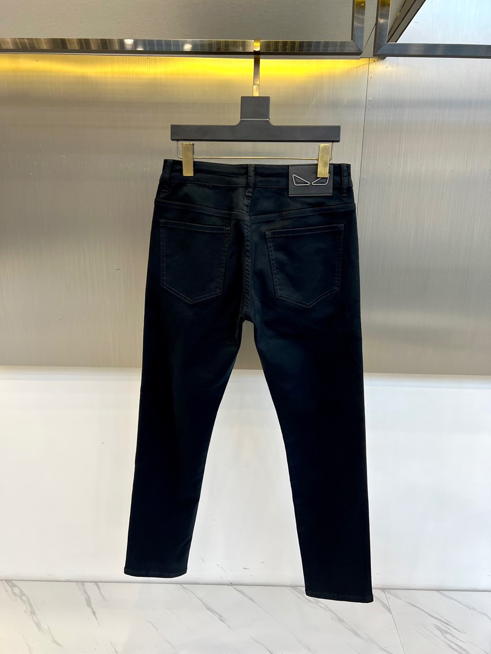 Fend芬迪、2025秋冬新品黑色牛仔裤，以深邃纯黑诠释意式奢华美学。后腰处装饰标志性棕色压纹皮质标牌，