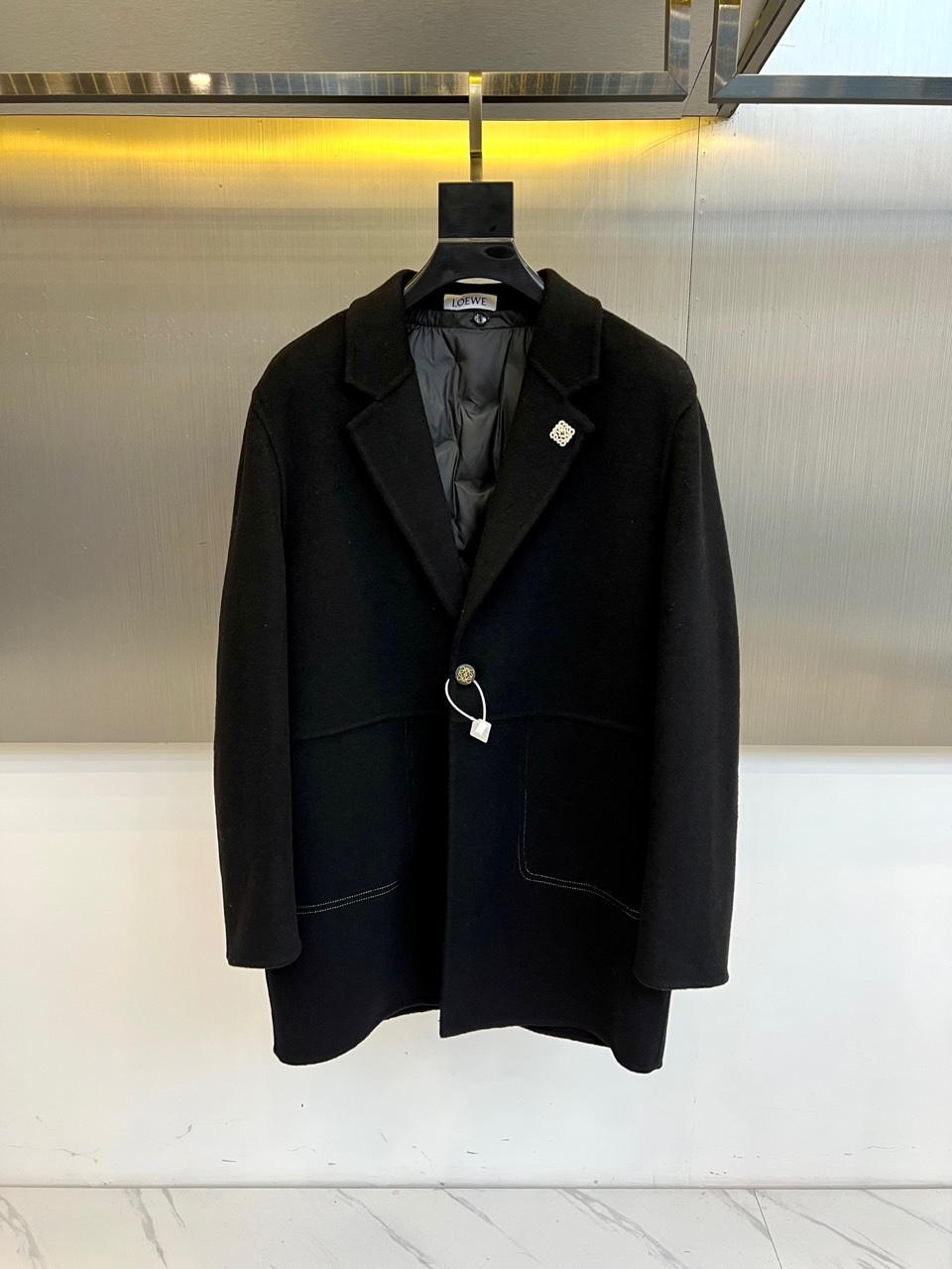 NO:613154,Low Loewe, the new wool coat for autumn and winter 2025. The inner down vest is made of light brown wool blend fabric to demonstrate the style of a modern gentleman. This vest adopts a classic suit collar design with smooth and neat lines, a single metal button embellishes the front, and the brand's iconic emblem is decorated on the left chest. The edges of the symmetrical pockets on both sides are decorated with white lines, forming a subtle contrast with the main body. The interior is filled with black down to ensure light warmth.  The fabric is made of a blend of 68.2 wool and 31.8 polyester fiber, and the lining is polyester fiber, which not only maintains the natural texture of wool, but also adds stiffness to the fabric. Its design perfectly integrates formal elements and practical functions. The light brown tone highlights a warm temperament. It can be paired with a shirt to create a business casual look, or layered under a jacket to enhance the overall sense of hierarchy.  From business meetings to weekend leisure, this vest, with its simple but not simple design language, has become the finishing touch to improve your dressing taste in autumn and winter. The details reflect the brand's craftsmanship, such as precise tailoring and exquisite fabric selection, making the item not only warm and practical, but also an elegant statement showing personal fashion attitude. 48-56 (model 173, 143 pounds, upper body size 50),, loewe, jackets & coats, shirts, down jacket, business suit, alexander  wang19860909Low罗意威、2025秋冬新品羊毛大衣.内里羽绒马甲以浅棕色羊毛混纺面料演绎现代绅士风度.这款马甲采用经典西装领设计,线条流畅利落,单颗金属纽扣点缀前襟,左胸处装饰品牌标志性徽章.两侧对称口袋边缘饰以白色线条,与主体形成微妙对比.内里填充黑色羽绒,确保轻盈保暖性. 面料选用68.2羊毛与31.8聚酯纤维混纺材质,里料为聚酯纤维,既保持羊毛的天然质感,又增添面料的挺括度.其设计将正装元素与实用功能完美融合,浅棕色调彰显温润气质,可搭配衬衫打造商务休闲造型,亦能叠穿在外套内提升整体层次感. 从商务会晤到周末休闲,这件马甲以其简约而不简单的设计语言,成为秋冬季节提升穿搭品味的点睛之笔.细节处体现品牌匠心工艺,如精准的剪裁与考究的面料选择,让单品在保暖实用之余,更成为展现个人时尚态度的优雅宣言.48-56（模特173,143斤上身50码）,,loewe,jackets & coats,shirts,down jacket,business suit,alexander wang,Men's clothing