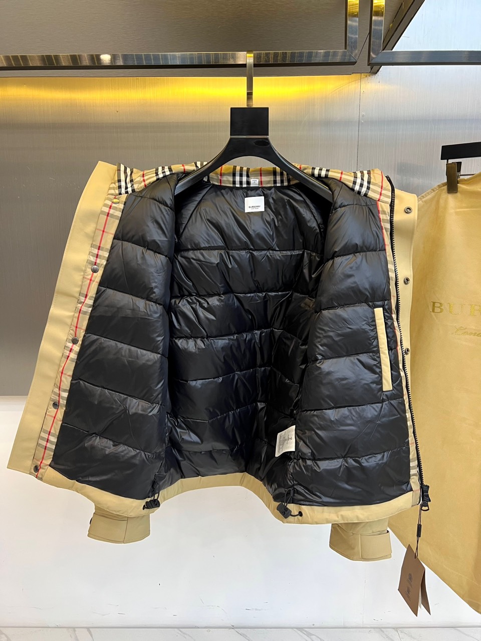 Bur巴宝莉（高端白鹅绒）、2025秋冬新品男士连帽羽绒外套，以经典卡其色演绎现代英伦风尚。立体剪裁的连