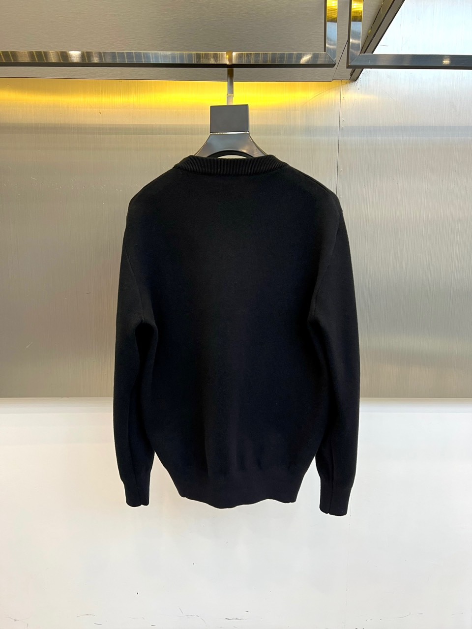 Prad普拉、2025秋冬新品白色针织毛衣，以极简主义美学诠释当代优雅。这款毛衣采用经典圆领设计，左胸位