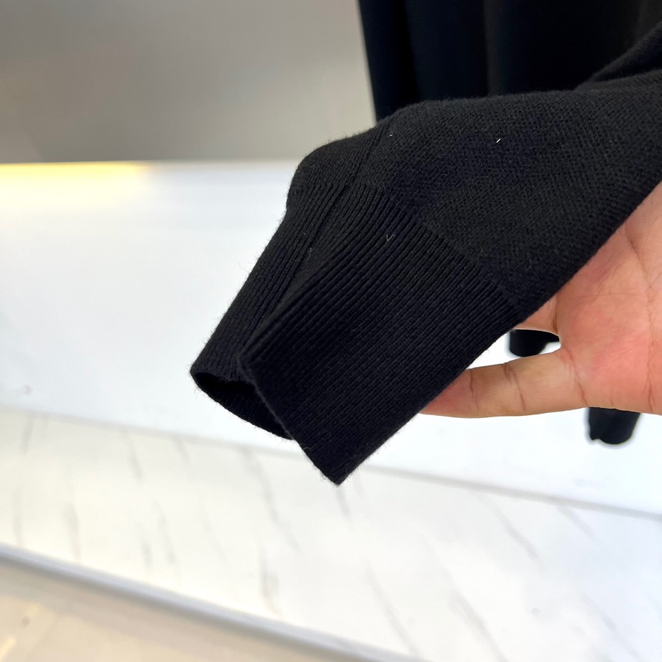 Prad普拉、2025秋冬新品白色针织毛衣，以极简主义美学诠释当代优雅。这款毛衣采用经典圆领设计，左胸位