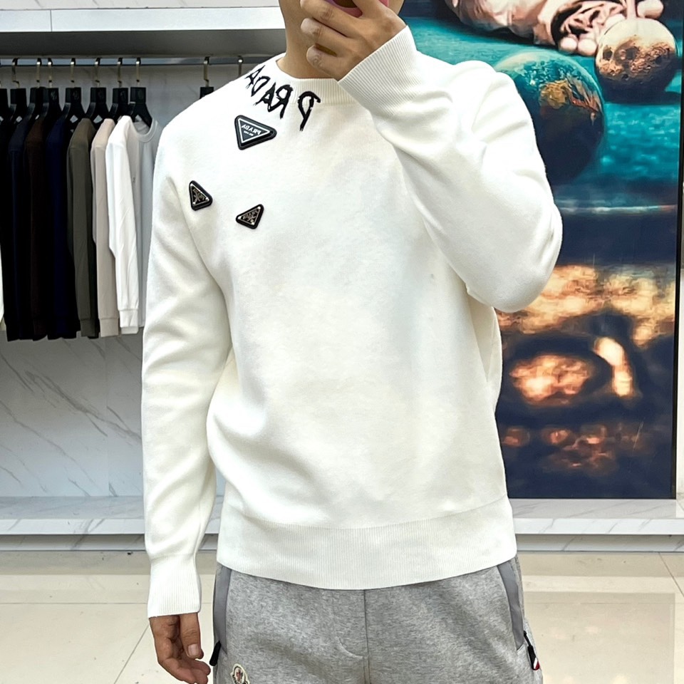 Prad普拉、2025秋冬新品白色针织毛衣，以极简主义美学诠释当代优雅。这款毛衣采用经典圆领设计，左胸位