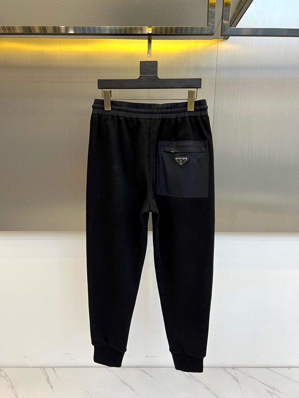 Prad普拉、2025秋冬新品运动休闲长裤，以束脚廓形重塑奢华运动美学。款式采用高腰抽绳设计，两侧搭载隐