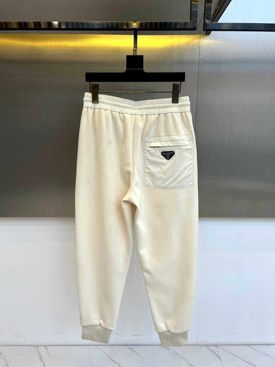 Prad普拉、2025秋冬新品运动休闲长裤，以束脚廓形重塑奢华运动美学。款式采用高腰抽绳设计，两侧搭载隐
