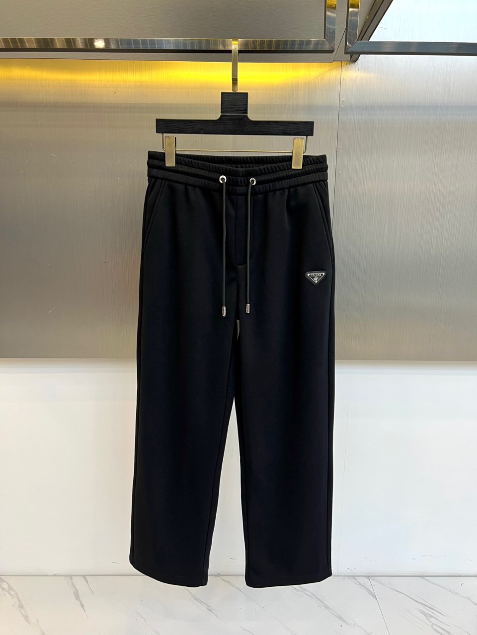 Prad普拉达、2025秋冬新款加绒运动卫裤，这款长裤采用直筒剪裁设计，松紧腰头搭配可调节抽绳，确保贴合