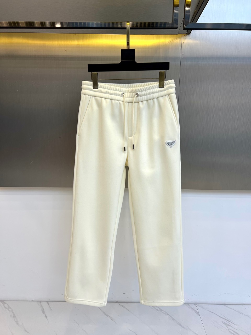 Prad普拉达、2025秋冬新款加绒运动卫裤，这款长裤采用直筒剪裁设计，松紧腰头搭配可调节抽绳，确保贴合